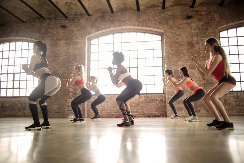 Group of beginners practicing squats as part of a calisthenics routine to improve leg strength and flexibility.