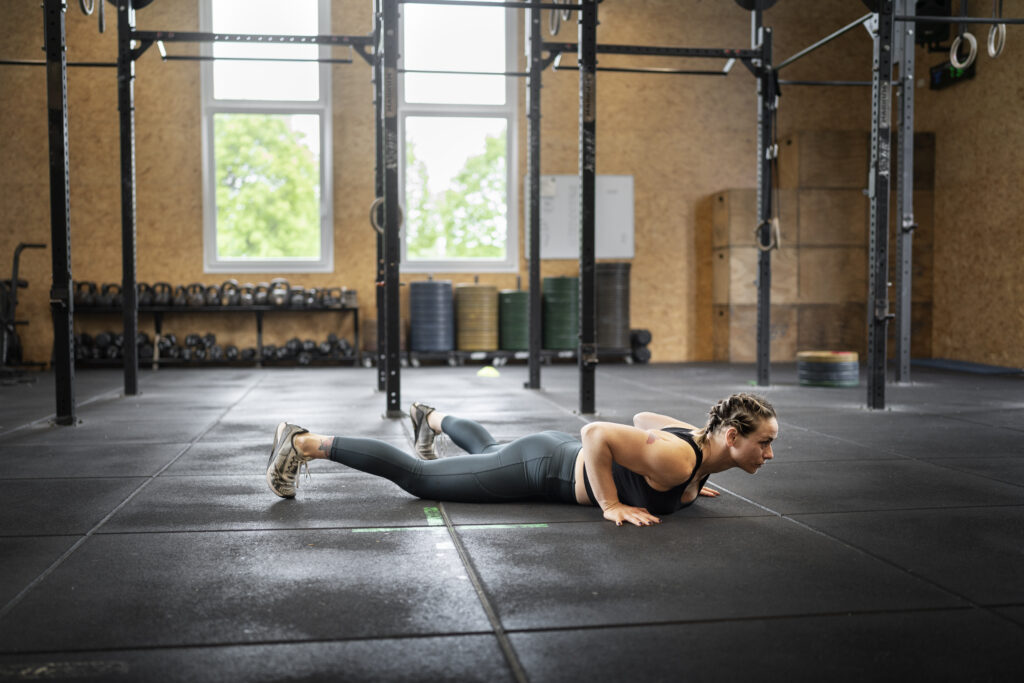 Dynamic shot of an individual doing a burpee, demonstrating a challenging full-body movement in a HIIT workout.